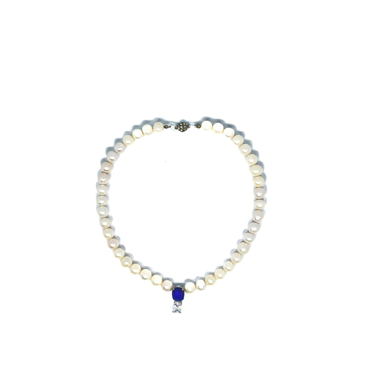 White Freshwater Pearl Necklace wit Searovski Crystal and Saphhire Drop on white background viewed from above