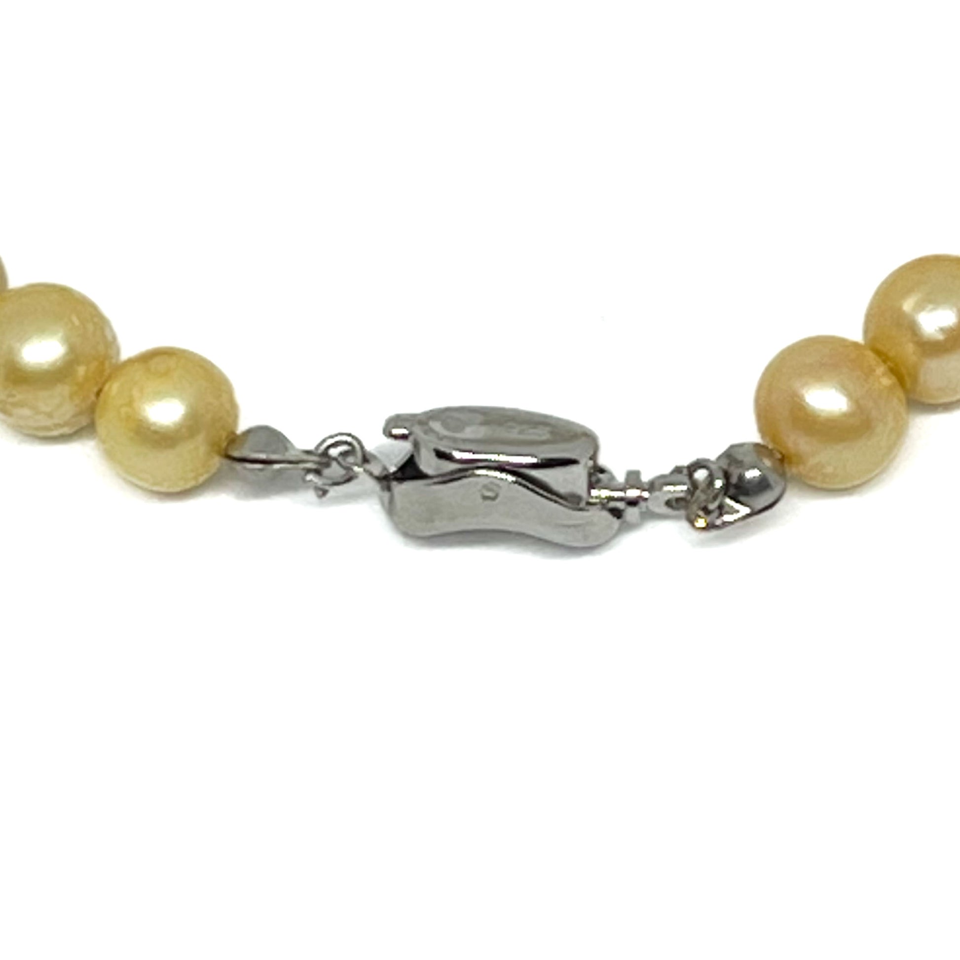 Close up of Silver Clasp on Gold Pearl Necklace.