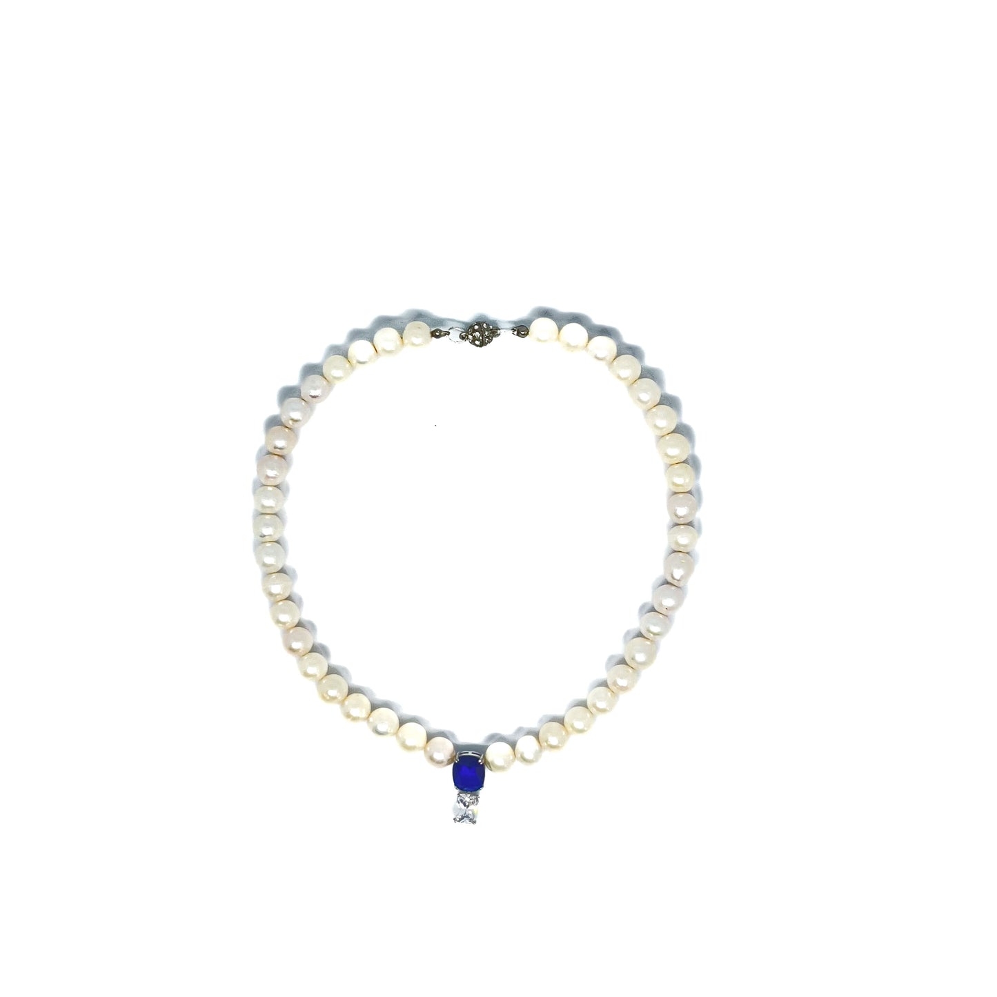 White Freshwater Pearl Necklace wit Searovski Crystal and Saphhire Drop on white background  viewed from above