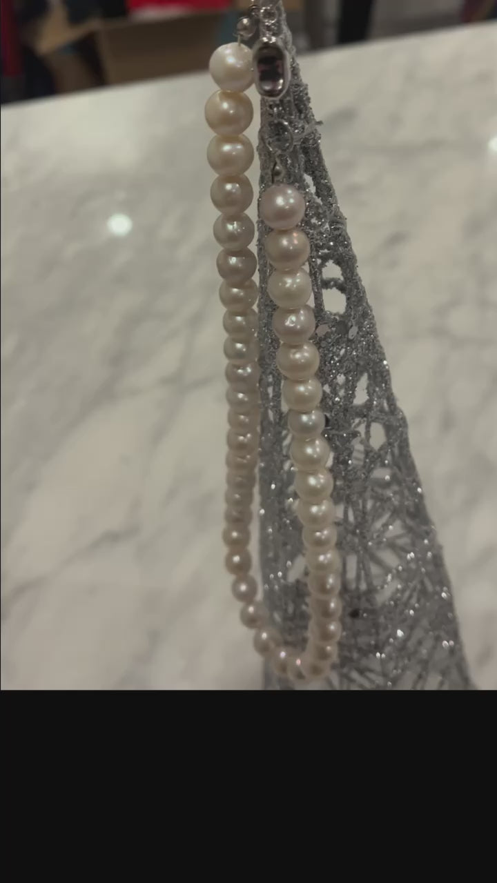 Video of 10mm AAA Quality Freshwater Cultured Pearl Necklace in White hung from an ornament and a gold floral pattern background.